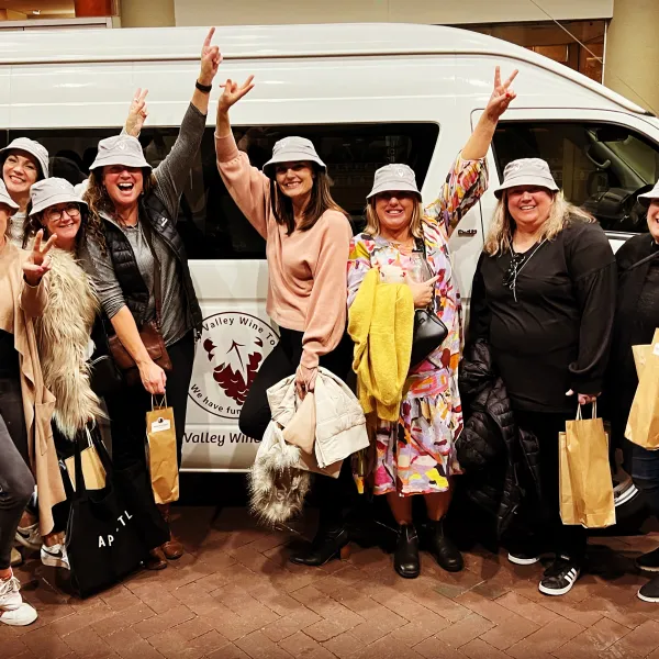 a group of people standing in front of a car posing for the camera