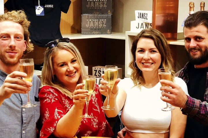 a couple of people are drinking from a wine glass posing for the camera