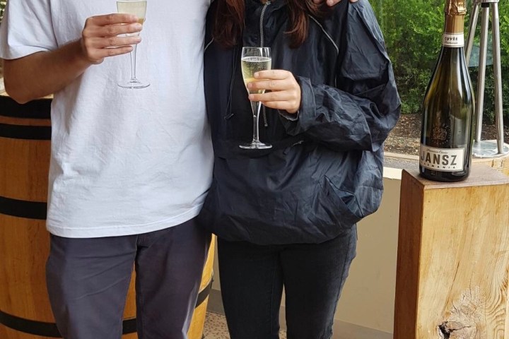 a person standing next to a glass of wine