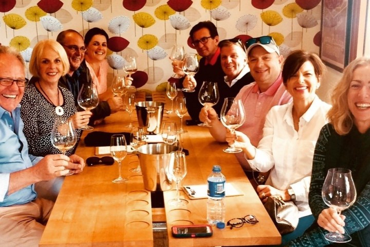 a group of people sitting at a table with wine glasses