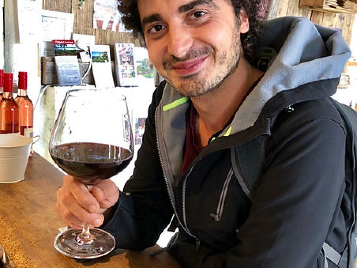 a man sitting at a table with wine glasses